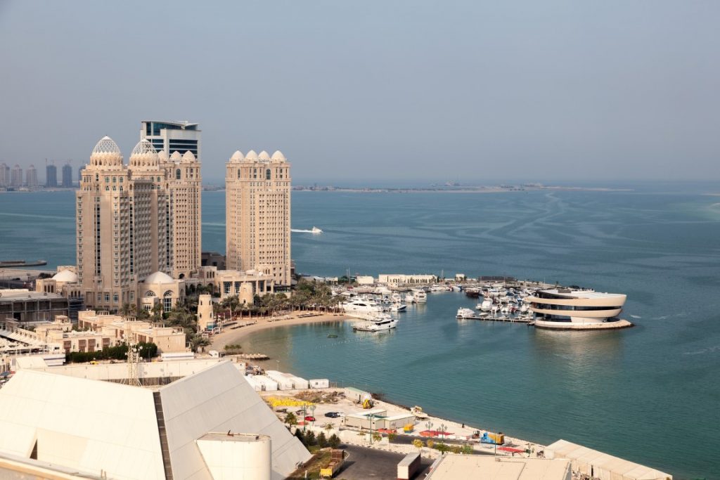 An image of the sea, and towering buildings in Doha, Qatar