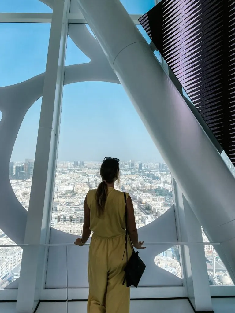 A woman looking at the city of Dubai from the Dubai Frame