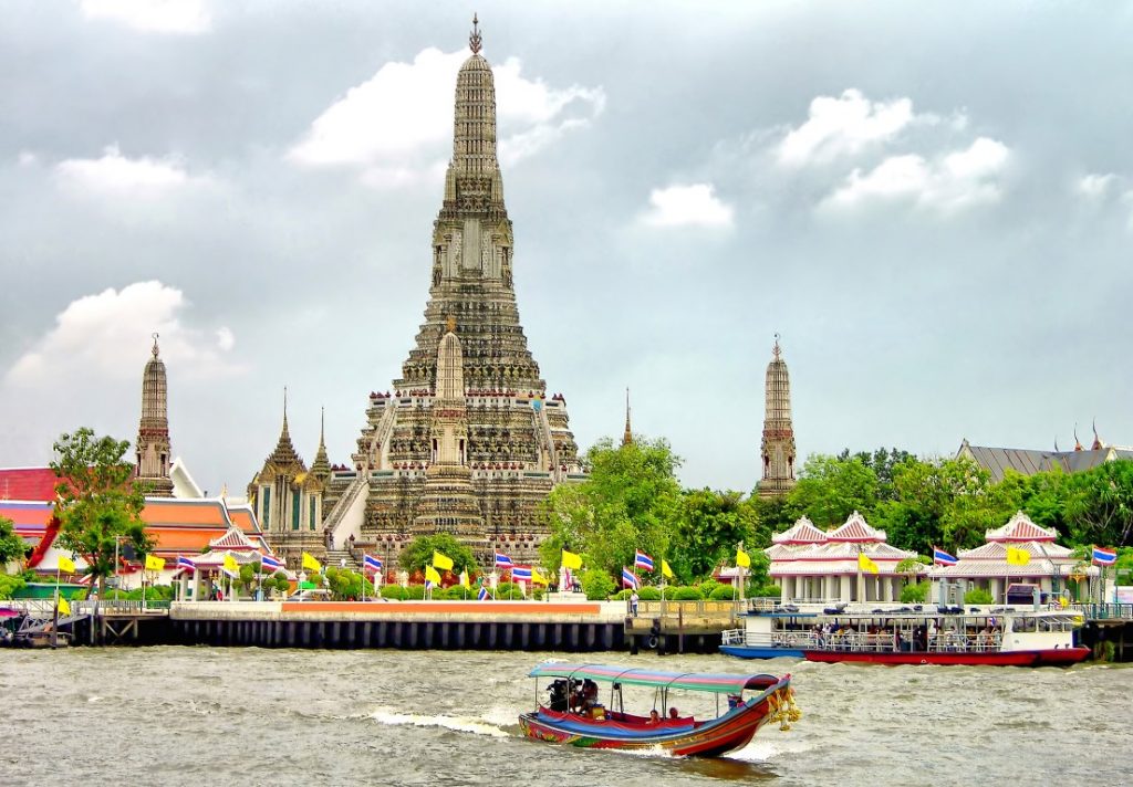 Image of a boat in front of a temple in Bangkok, inserted in a post about the best Bangkok boat tours.