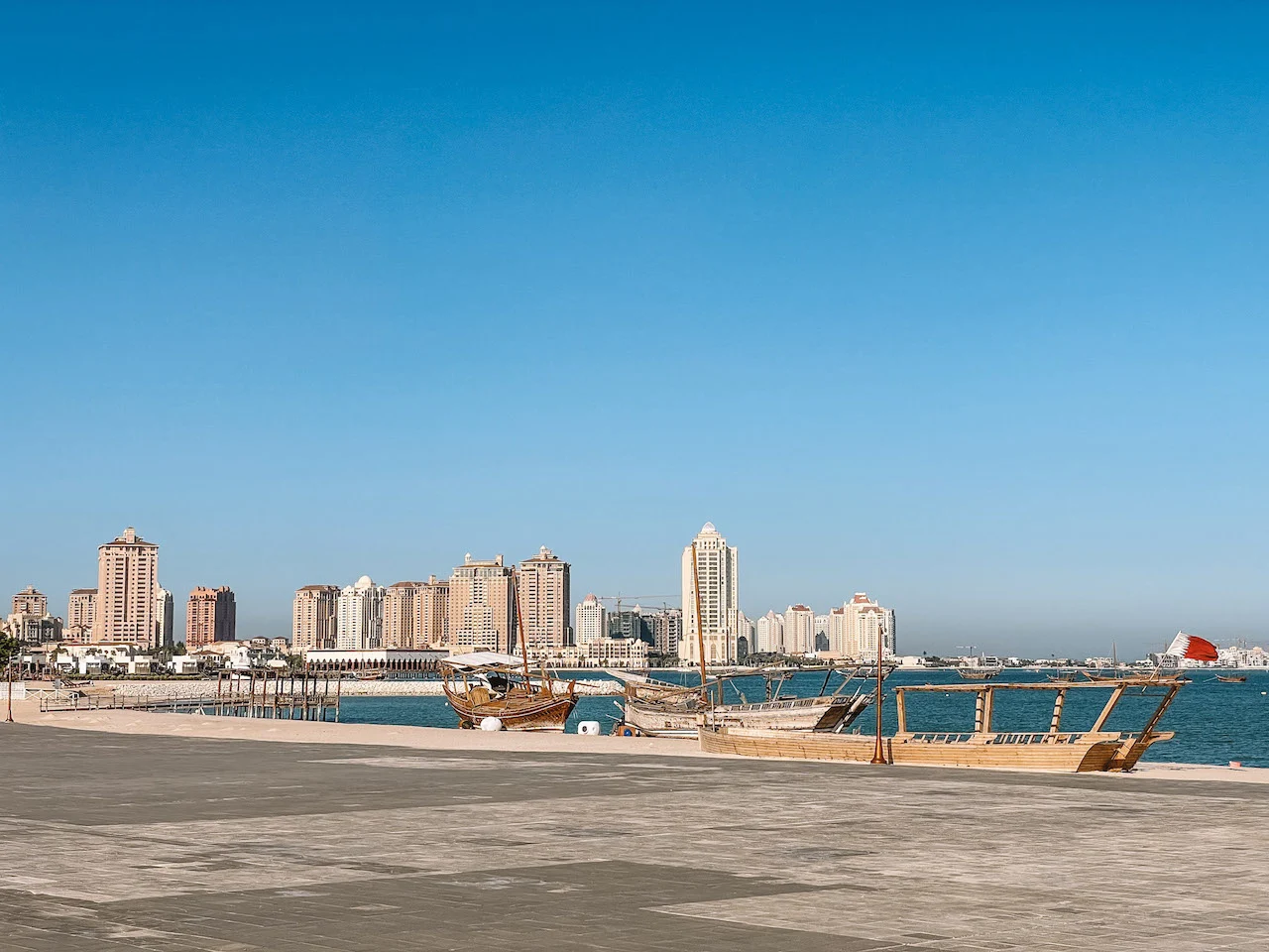 Doha Corniche, with traditional wooden boats in the water, and buildings seen in the distance