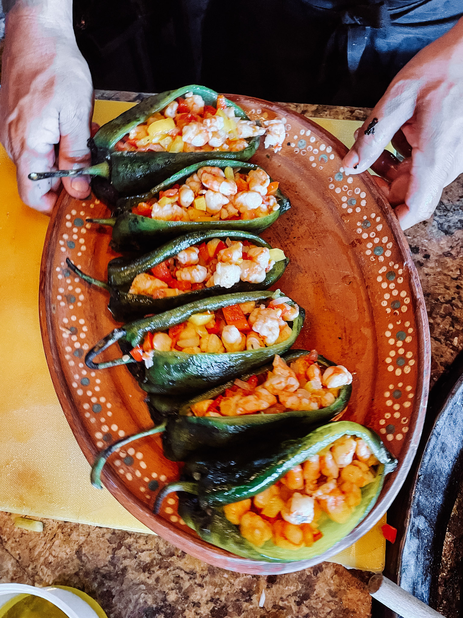 Stuffed pepper disposed in a terracotta tray in a cooking class