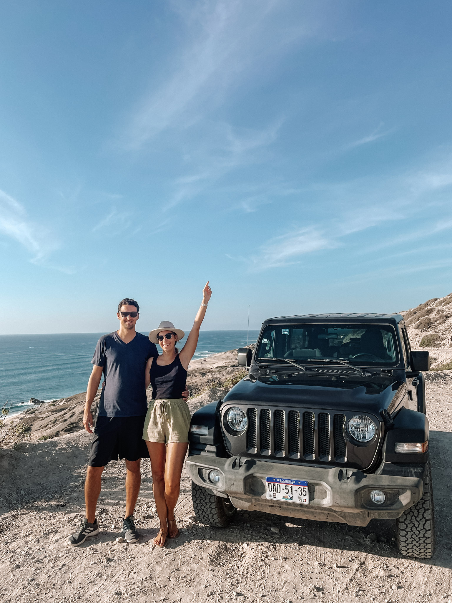 A couple smiling next to a jeep in Cabo Pulmo 