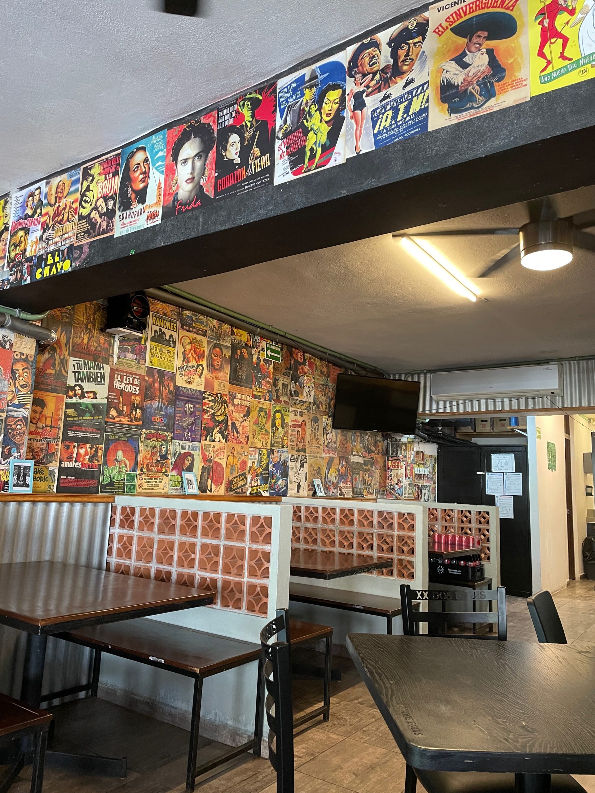 Image of Taqueria Coapeñitos with empty tables and walls covered in movie posters