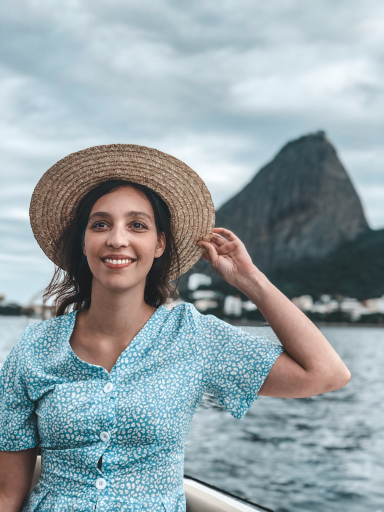 A woman wearing a blue dress and a hat, smiling