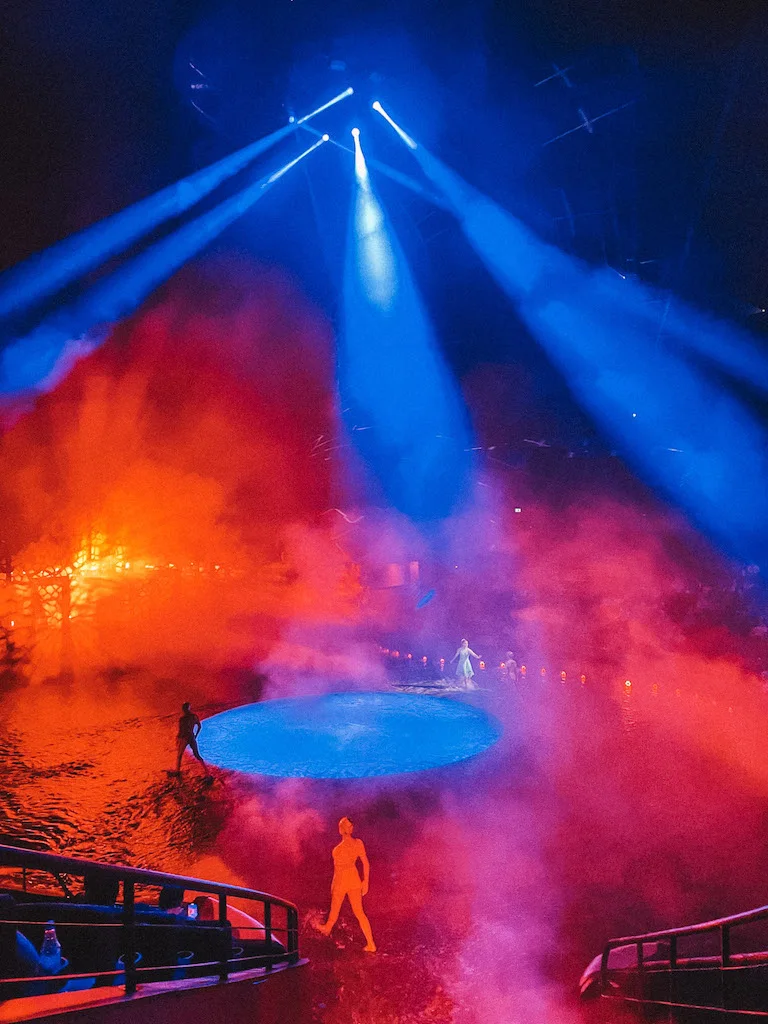 The stage of La Perle show with three dancers and colorful lights