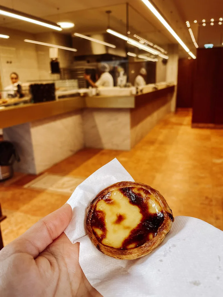 A hand holding a pastel de nata