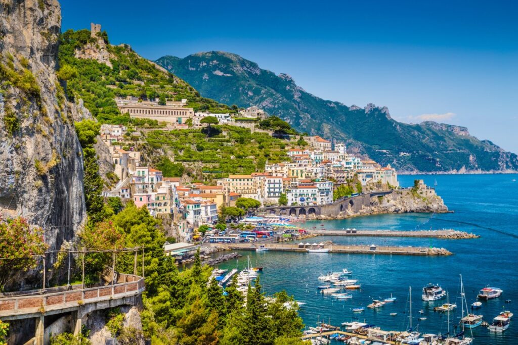 Image of the town of Amalfi facing the blue sea, inserted in a post about Sorrento vs Positano vs Amalfi 