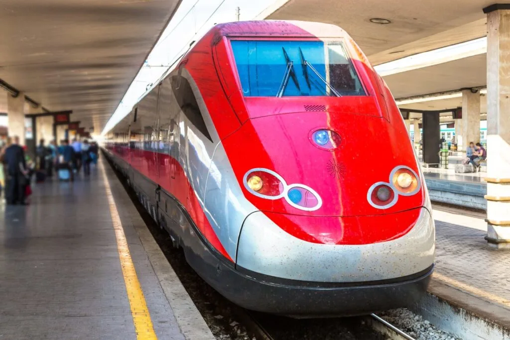 A modern red and gray train inside a station