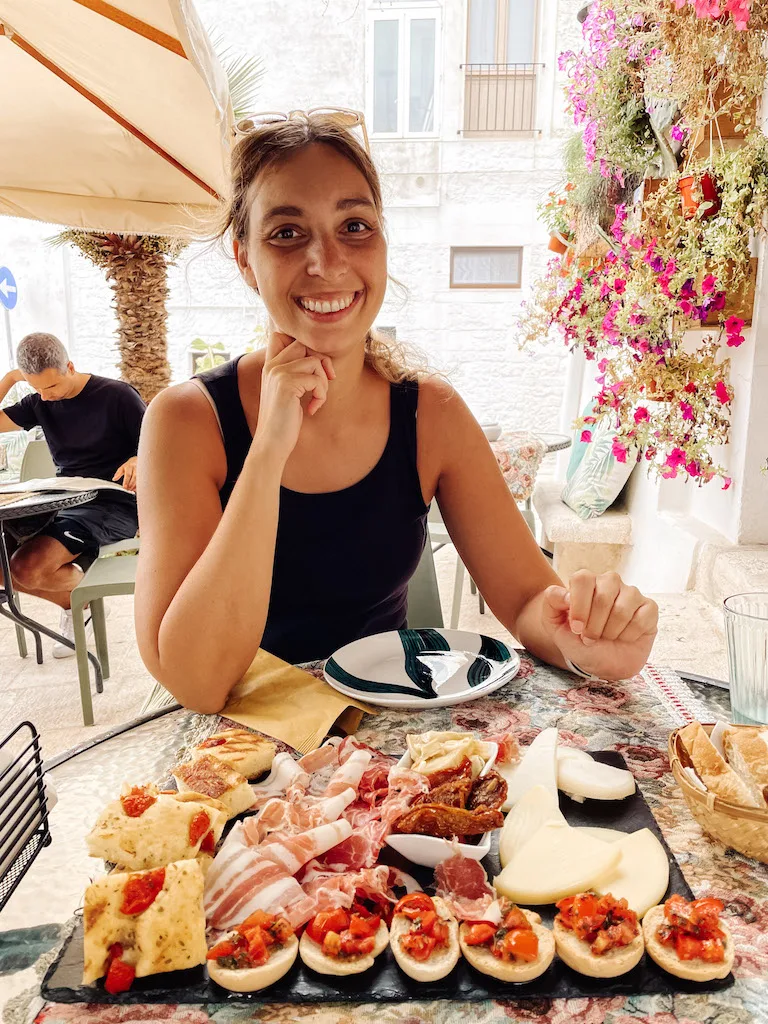 Woman in front of a charcuterie board.