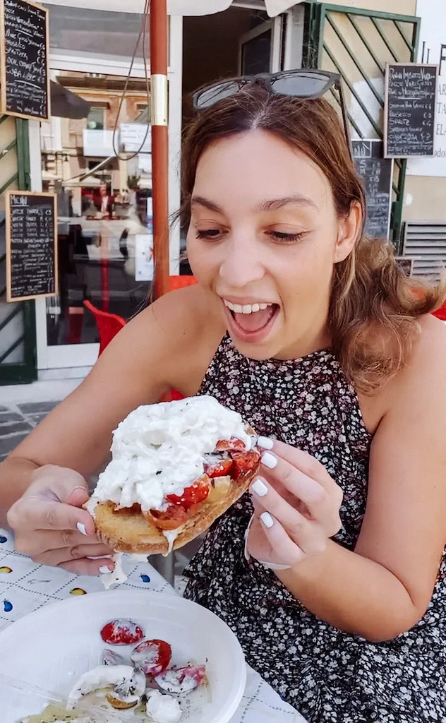 A woman about to eat a bruschetta in Rome