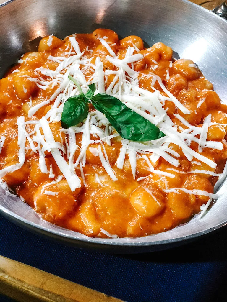 A dish of gnocchi with tomato sauce and cheese