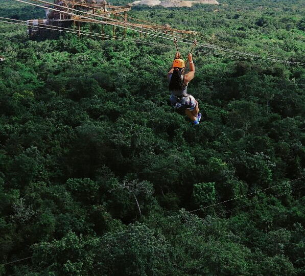 Woman ziplining in Cancun over the jungle at Xplor Park.