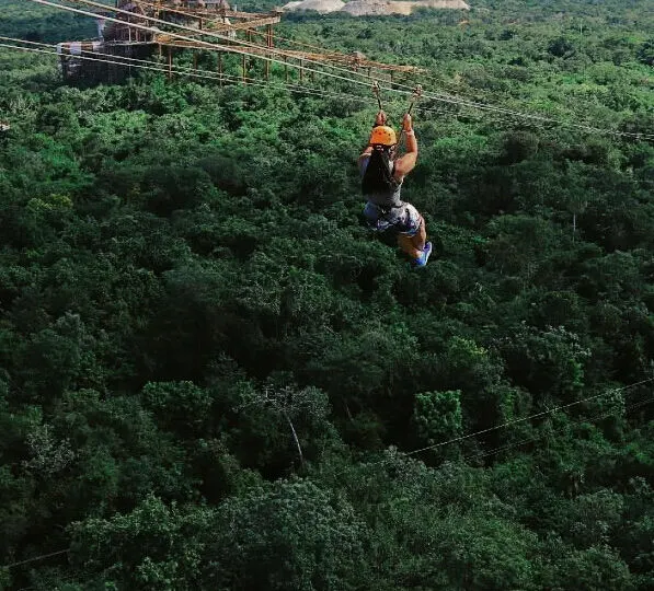 Woman ziplining in Cancun over the jungle at Xplor Park.