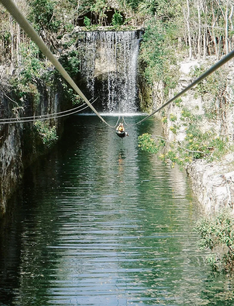 Woman ziplining over the water at Xplor park.