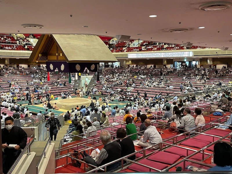 A sumo wrestling arena, with audience looking at the center stage