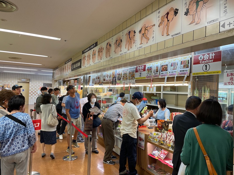 A snacks' bar at a Sumo Wrestling arena, with a line of Japanese people