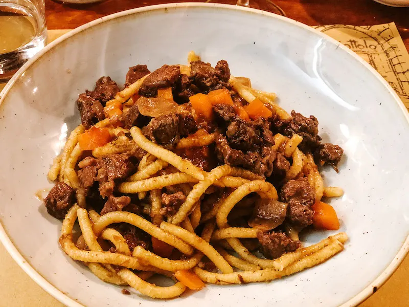 A dish of pasta with meat sauce served in a white plate