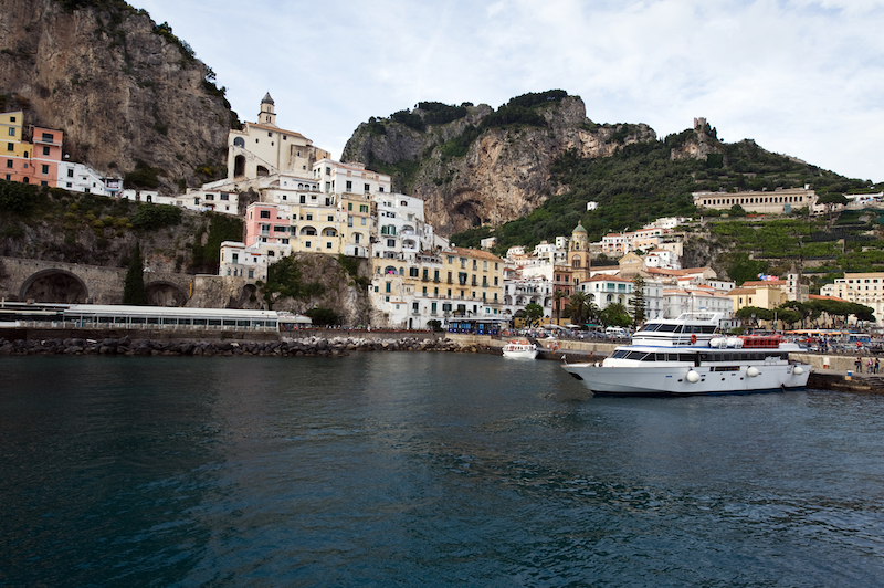 Boat docked in Amalfi with the town of Amalfi in the background.