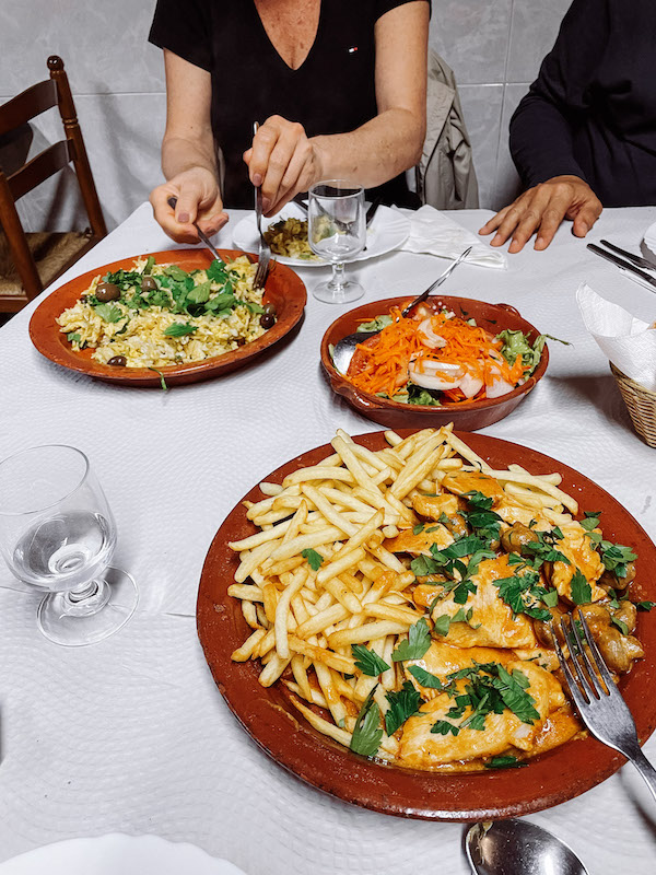 Three plates on the table with Portuguese food.