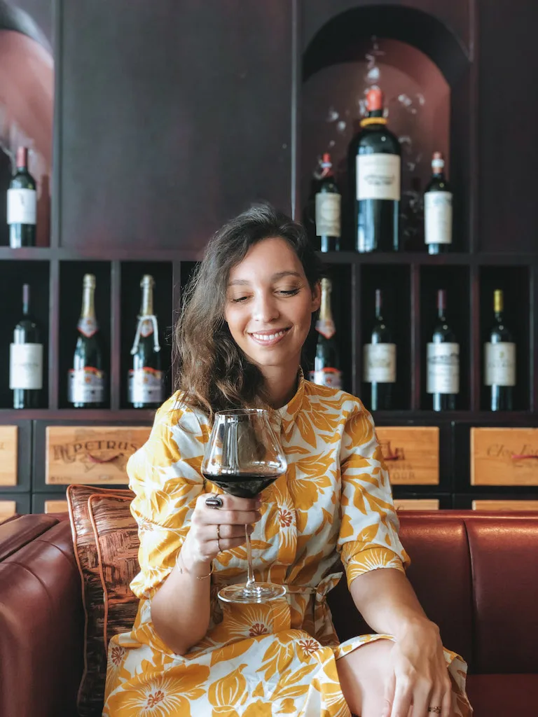 Woman with a wine glass in hand at a wine bar in Bologna