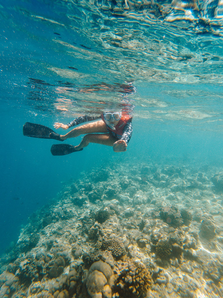 Girl with a snorkel mask swimming in blue waters