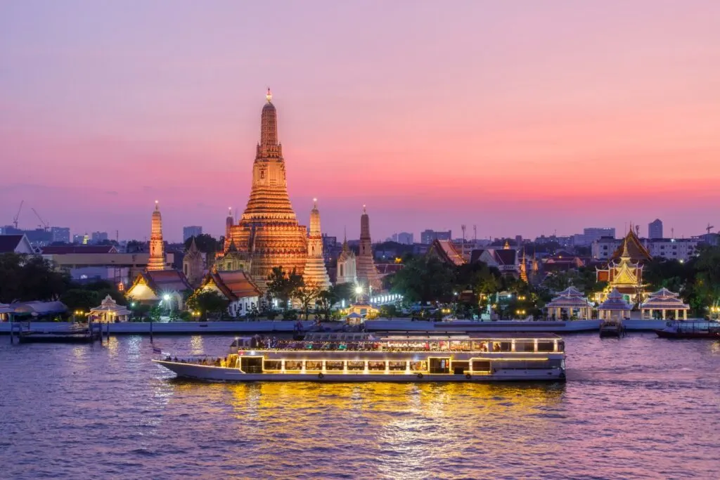 Image of a cruise in the Chao Phraya River, with Wat Arun temple in the background at dusk, inserted in a post about dinner cruises in Bangkok