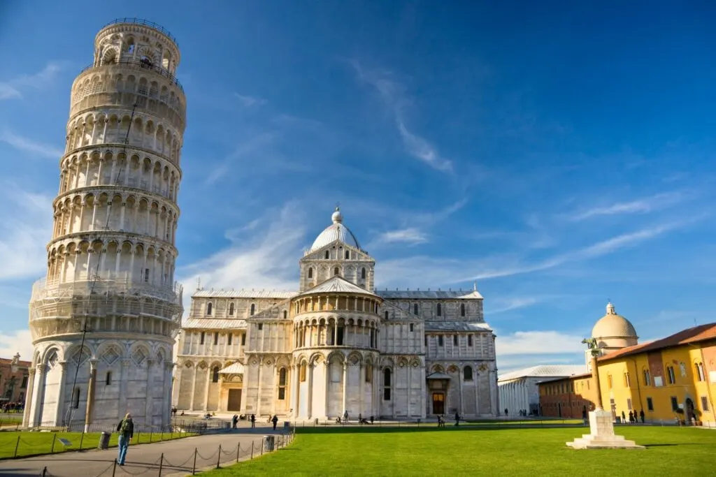 Image of the Leaning Tower of Pisa with the Cathedral in the background in Piazza dei Miracoli, inserted in a post about going on a Florence to Pisa Day Trip