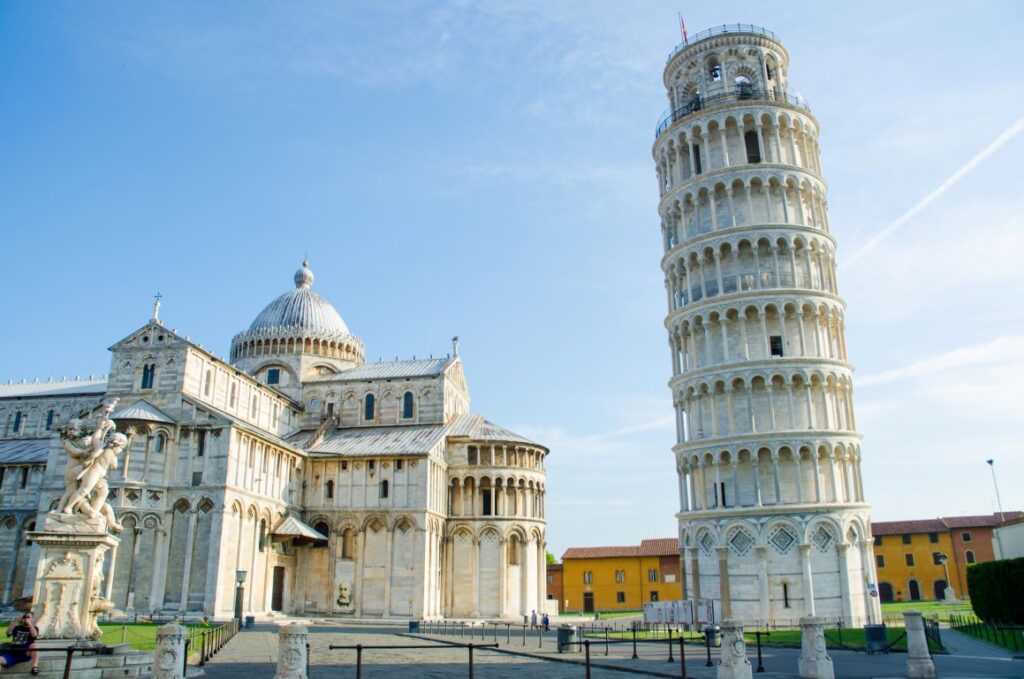 The famous tower of Pisa on the right of the image, leaning to the left where the Pisa Cathedral stands. Picture taken on a clear-skied, summer day