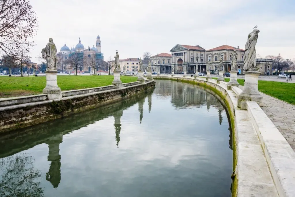 Image of Prato della Valle Square, with its waterway lined by statues and the Basilica of Santa Giustina in the back