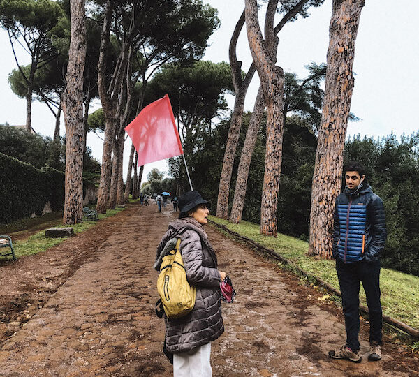 Guide with a flag and a tourist at the Roman Forum on a private tour in Rome.