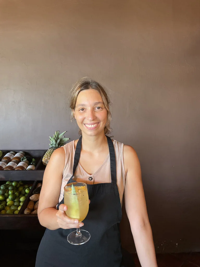 Woman smiling at the camera with a margarita in hand