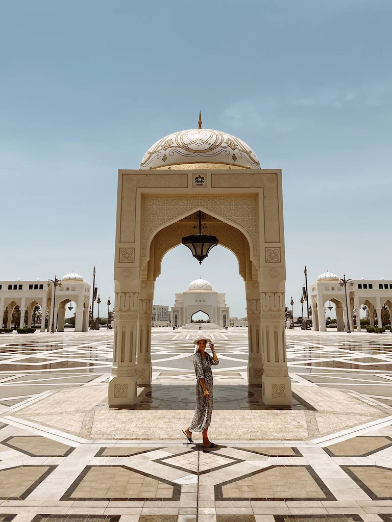 A woman posing in front of a landmark in Abu Dhabi