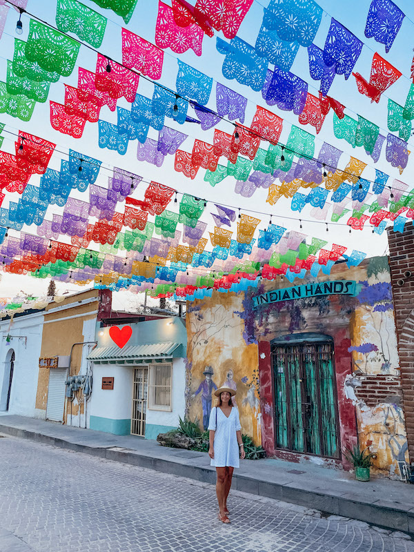 Woman standing in a street under colorful flags