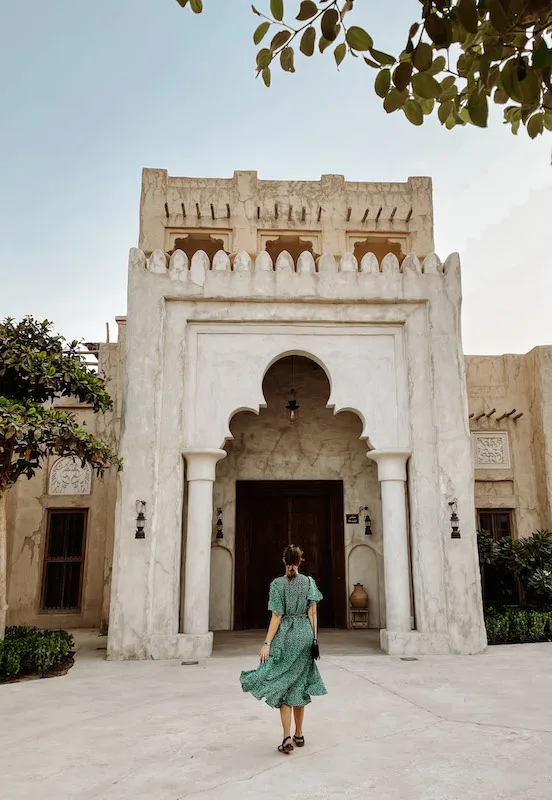 A woman standing in front of a building facade in Old Dubai