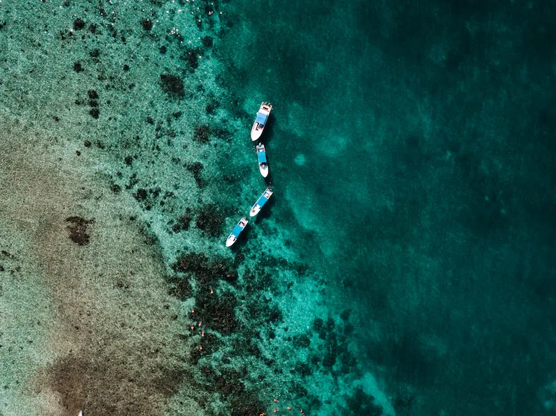 The sea in Sian Kaan, with four white and blue boats, seen from above