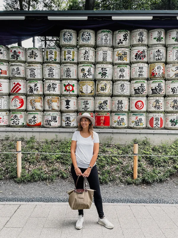 A woman posing in front of a wall filled with Japanese motifs