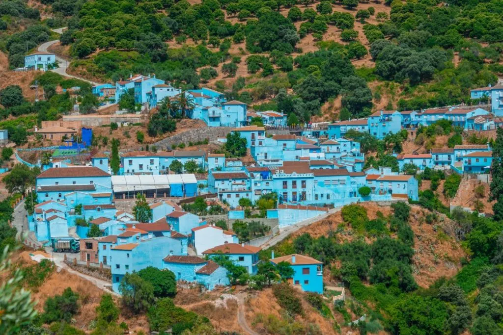 The blue houses of Juzcar, surrounded by green lushery