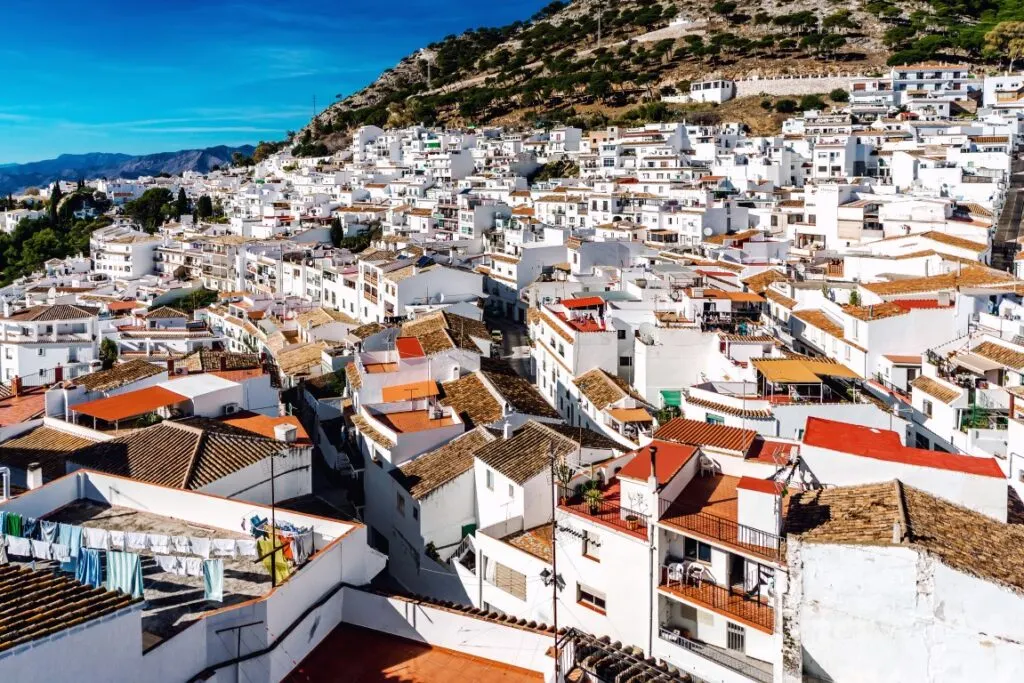 A drone shot of the white-washed town of Mijas, with mountains in the background