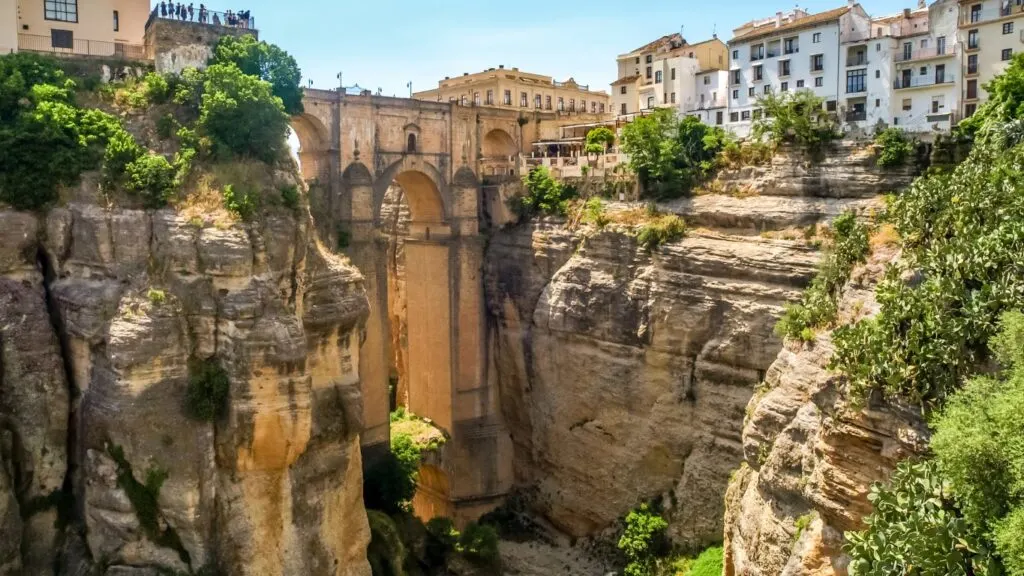 The gorge of Ronda, bridged by Puente Nuevo, and white houses on one side of the canyon