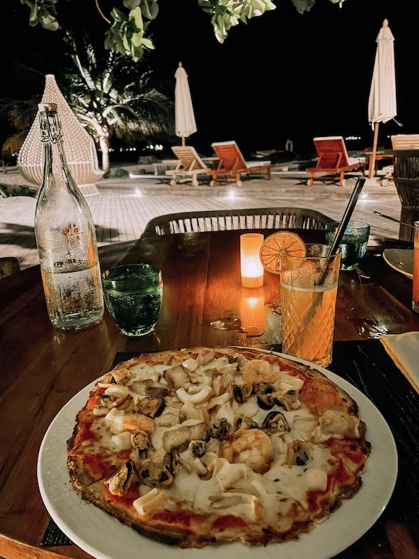 A plate of pizza, and two glasses set on a table