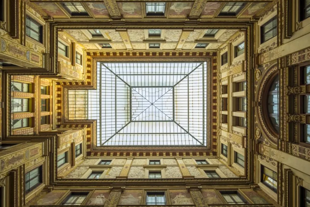 An image of the skylight at Galleria Sciarra, with the frescoed walls around it