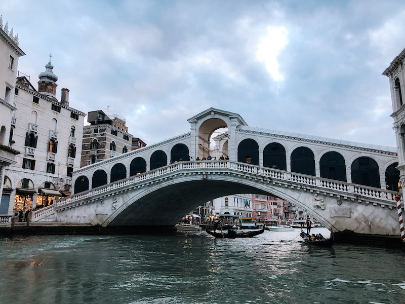 A bridge crossing a canal in Venice, with a gondola beneath it