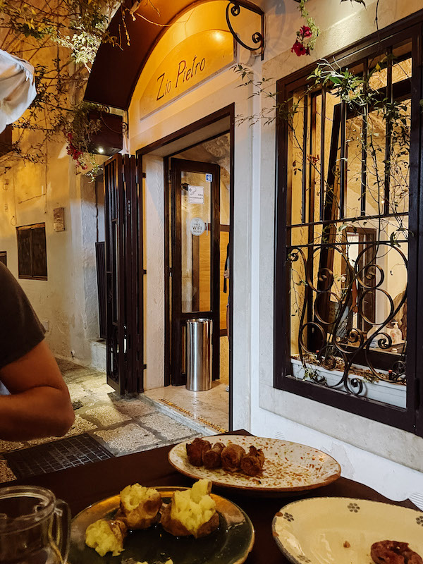 A restaurant's window seen from outside, and a few dishes of food placed on the table right next to it 