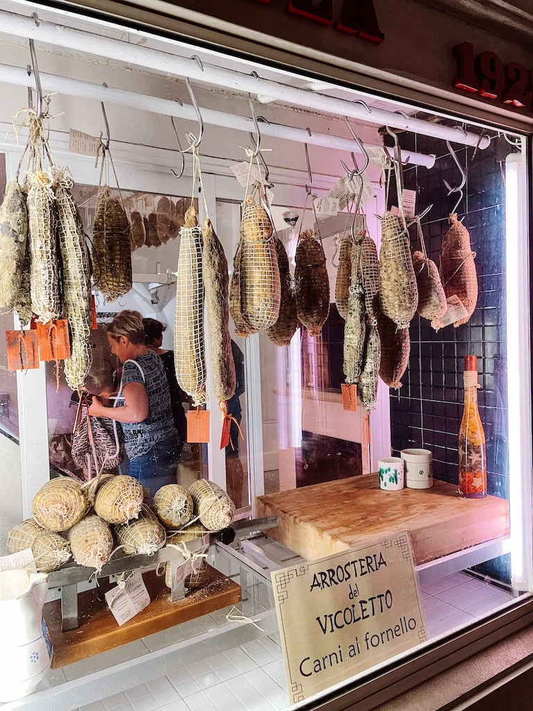 A butcher shop where women can be seen working in the back