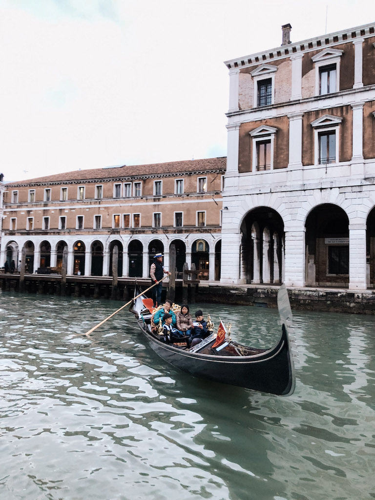 A gondola gliding along the canals in Venice, with buildings in the background