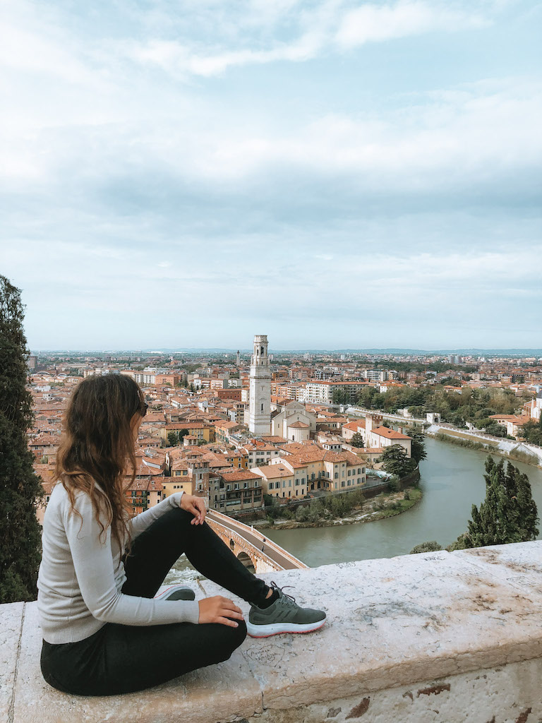 A woman looking over the city of Verona from a viewpoint