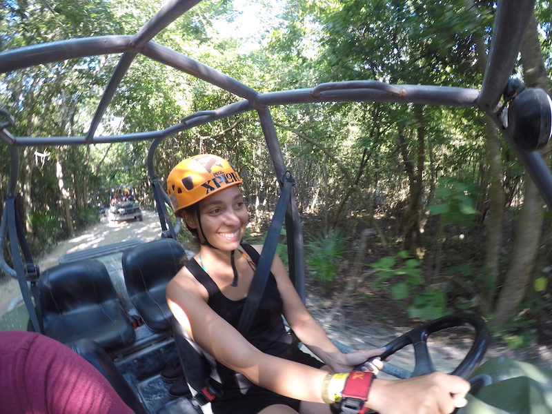 Woman with an orange helmet driving an ATV in an adventure park.