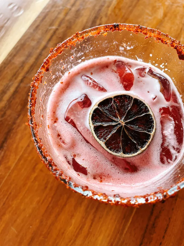 A red-rimmed glass wit margarita inside.