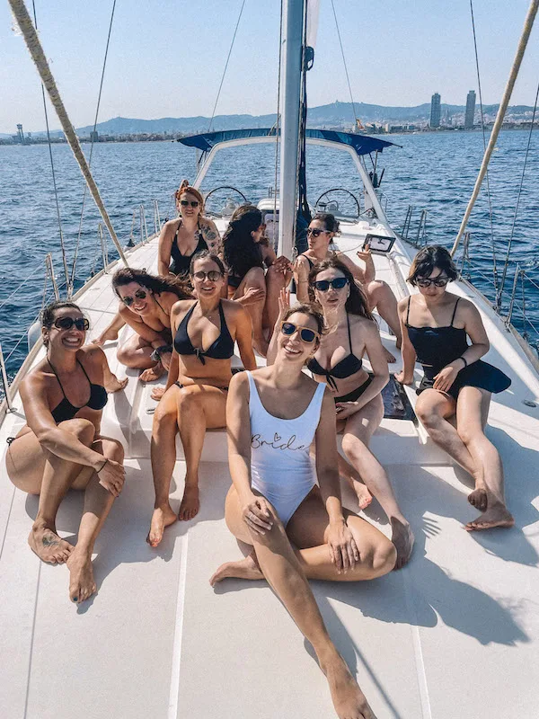 Group of women sitting on a catamaran smiling at the camera.