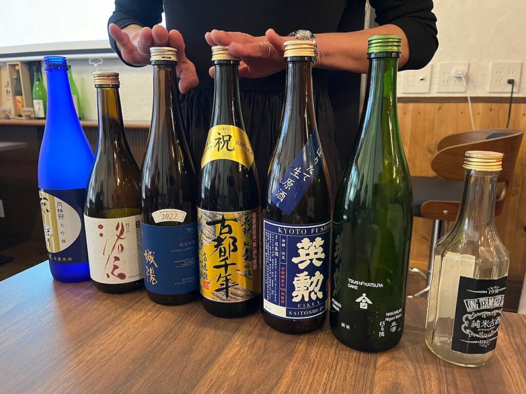 Seven different bottles of sake on a table.